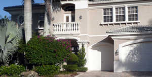 Two-story home with palm trees and bushes covered by Homeowners Insurance in Carrollwood, FL