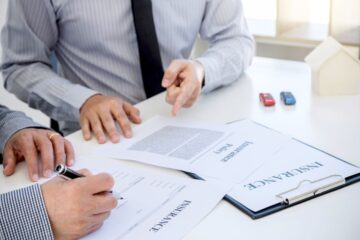 Men Sitting at Table with Paperwork for Liability Insurance in Forest Hills, FL