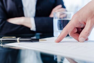 People Sitting at Desk Pointing at Papers on Desk for Liability Insurance in Riverview, FL