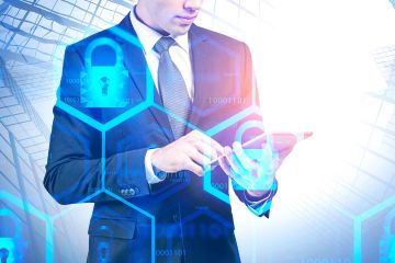 A man in a suit uses a tablet, overlaid with blue cybersecurity icons and binary code, in front of a blurred office building. This image conveys the concept of digital security in a modern business context.